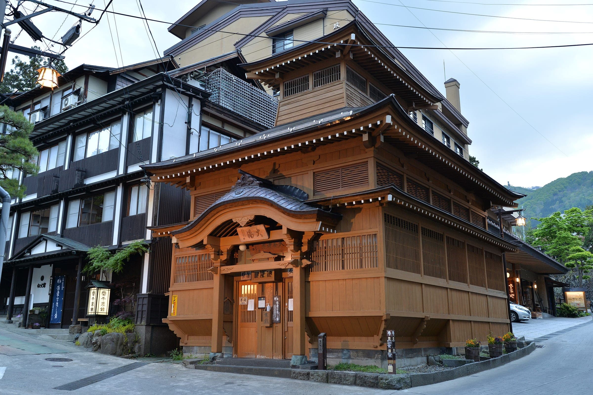 The wooden Oyu bathhouse stands at the centre of Nozawa Onsen with its curved gable roof.