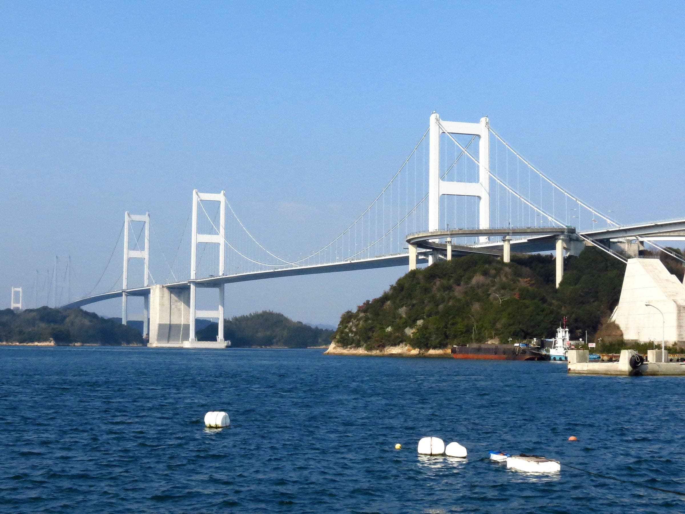 The three suspension spans of the Kurushima Kaikyo Bridge cross the strait from Imabari toward Oshima